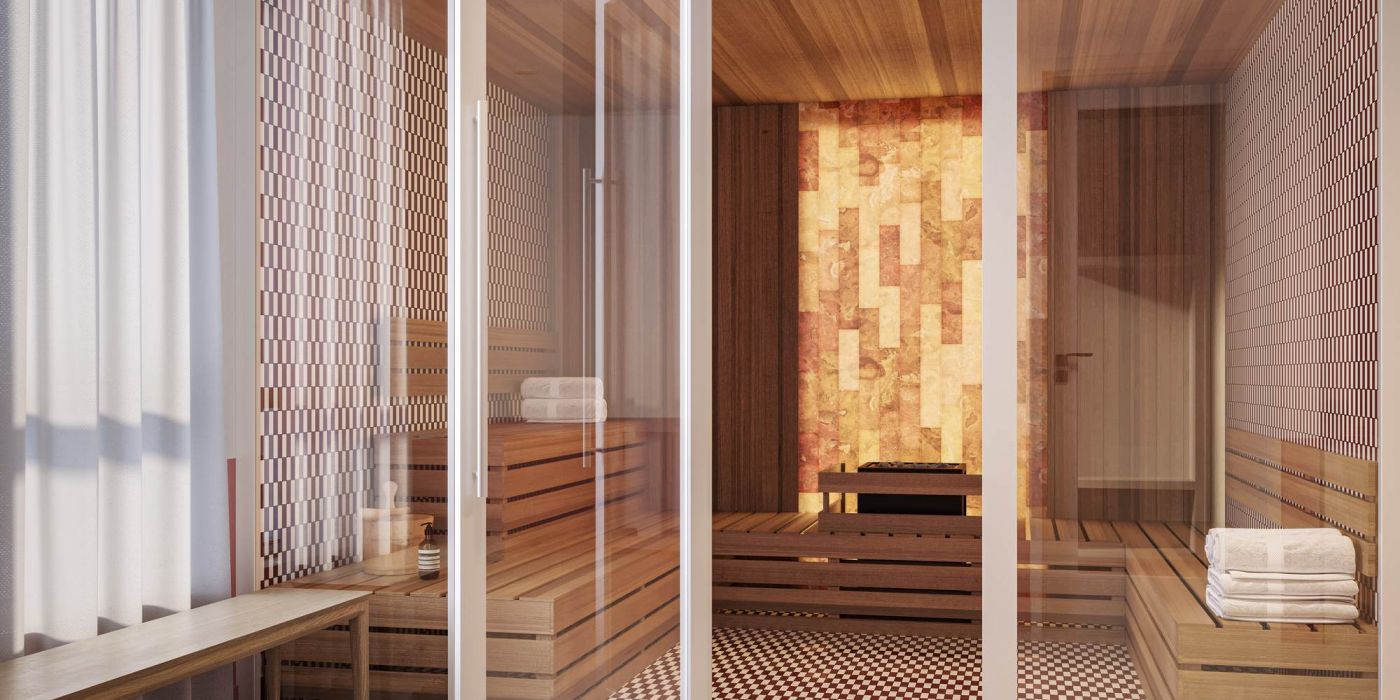 Modern sauna at VERVE Tempe featuring wood-paneled walls, built-in bench seating, and a glass door entry with soft ambient lighting.