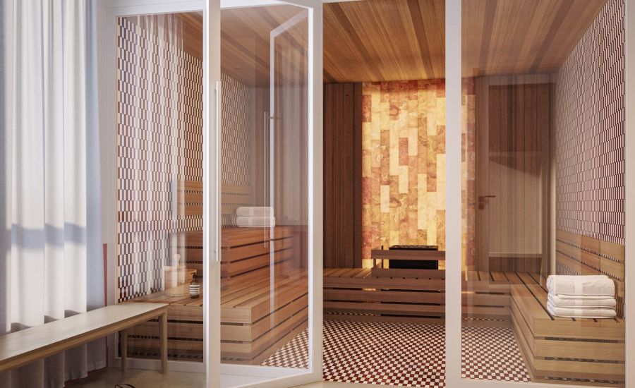 Modern sauna at VERVE Tempe featuring wood-paneled walls, built-in bench seating, and a glass door entry with soft ambient lighting.