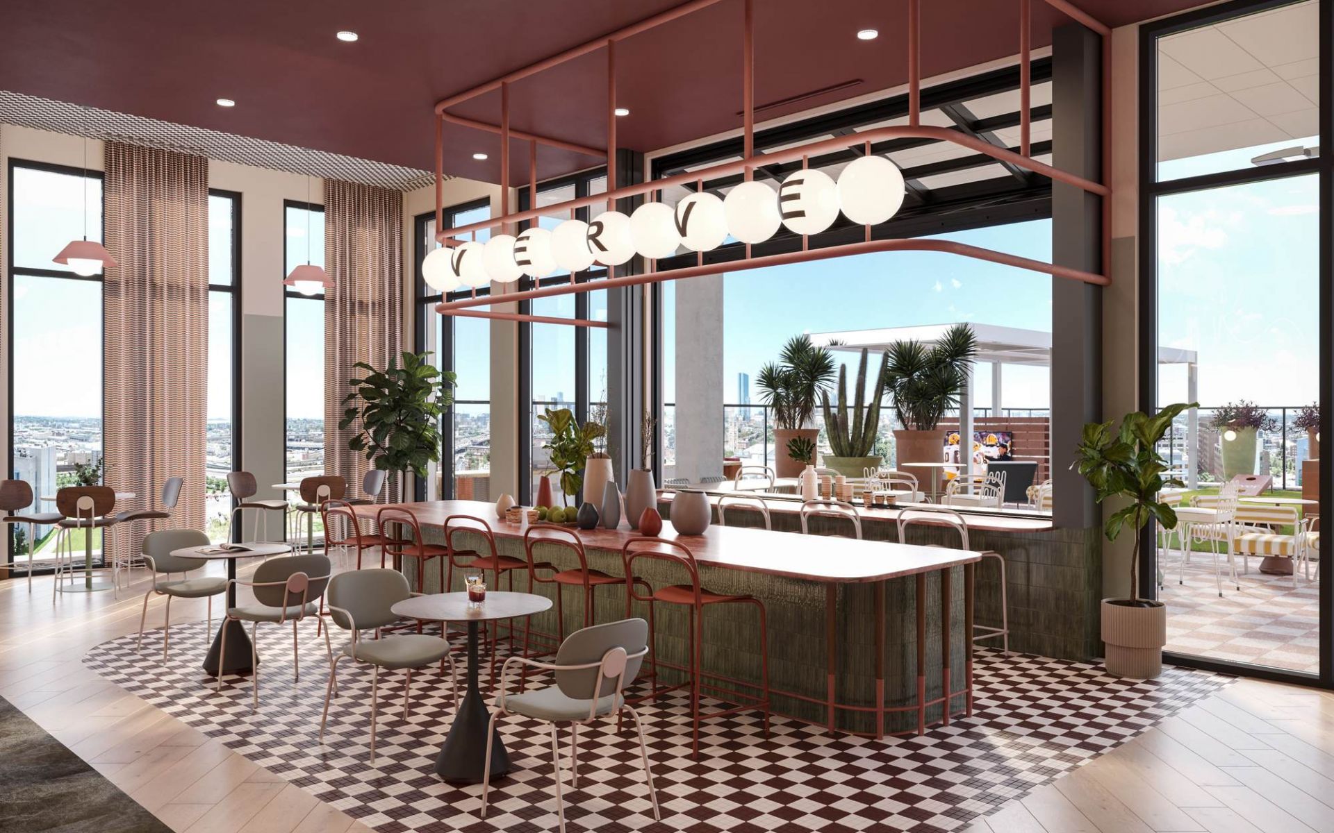 Stylish community kitchen at VERVE Tempe with a large island, globe pendant lighting, and modern seating surrounded by floor-to-ceiling windows.