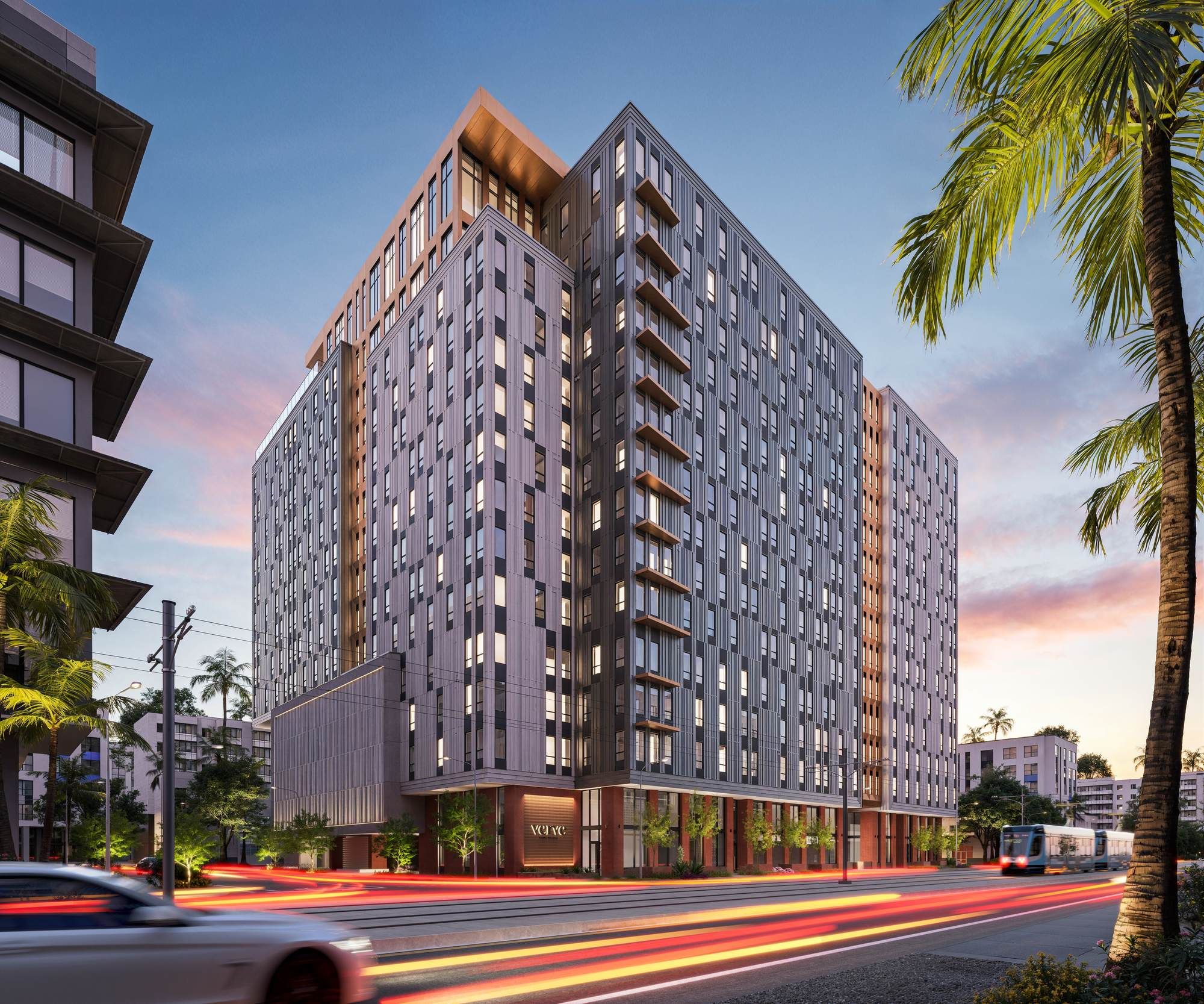 Street-level view of VERVE Tempe at sunset, highlighting the building’s sleek design, large windows, and vibrant location lined with palm trees and city lights.